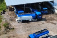 KETAHUAN: enam kendaraan transportir berlogo PT Sri Karya Lintasindo terpantau kamera drone sedang terparkir dan salah satunya menyedot solar dari sebuah tong besar yang diisi solar dari jerigen. (Foto: Ekslusif/Ist).