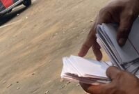 TERPANTAU: oknum calo saat bagi-bagi uang pengkondisian berbentuk amplop. (Foto: suararealitas.co).