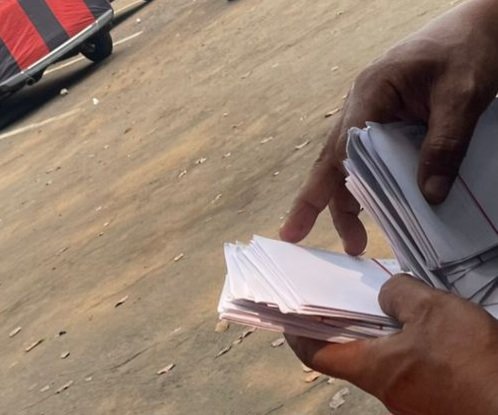 TERPANTAU: oknum calo saat bagi-bagi uang pengkondisian berbentuk amplop. (Foto: suararealitas.co).