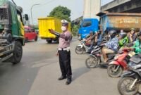 Polantas unit cakung mengatur lalin di jalan raya bekasi (foto:suararealitas)