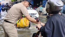 TERPANTAU: Lurah Kembangan Selatan, RM Pradana Putra saat tinjau banjir dan imbau para pengendara. (Foto: Istimewa).