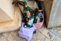 KETAHUAN: botol minuman keras bekas memabukkan berserakan di Kantor Desa Rajekwesi. (Foto: suararealitas.co)