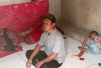 Arif duduk di dalam ruangan 3x3 meter berdinding bilik bambu yang ditinggalinya bersama istri dan dua anak. Rumah sempit ini menjadi tempat mereka bertahan hidup di tengah keterbatasan ekonomi