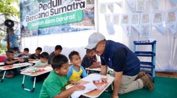 POTRET - Wakil Bupati Aceh Tamiang, Ismail menyaksikan penyerahan sepatu bagi anak penghuni Huntara Aceh Tamiang oleh Direktur Utama PTPN IV PalmCo. Selain menyiapkan lahan untuk pembangunan hunian, dukungan psikososial terus diperkuat PTPN IV melalui pemberian sepatu sekolah dan peluncuran Sekolah Darurat bekerjasama dengan benihbaik.com yang didirikan oleh Andy F Noya. (Foto: Istimewa).