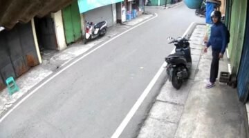 POTRET - terduga oknum polisi dengan senjata laras panjang di balik jaketnya. (Foto: Tangkapan Layar/Ist).