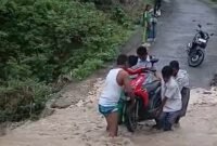 POTRET - amblasnya jalan penghubung dua desa di Rote Ndao tanpa adanya solusi nyata, anak sekolah harus menantang arus. (Foto: Tangkapan Layar/Ist).