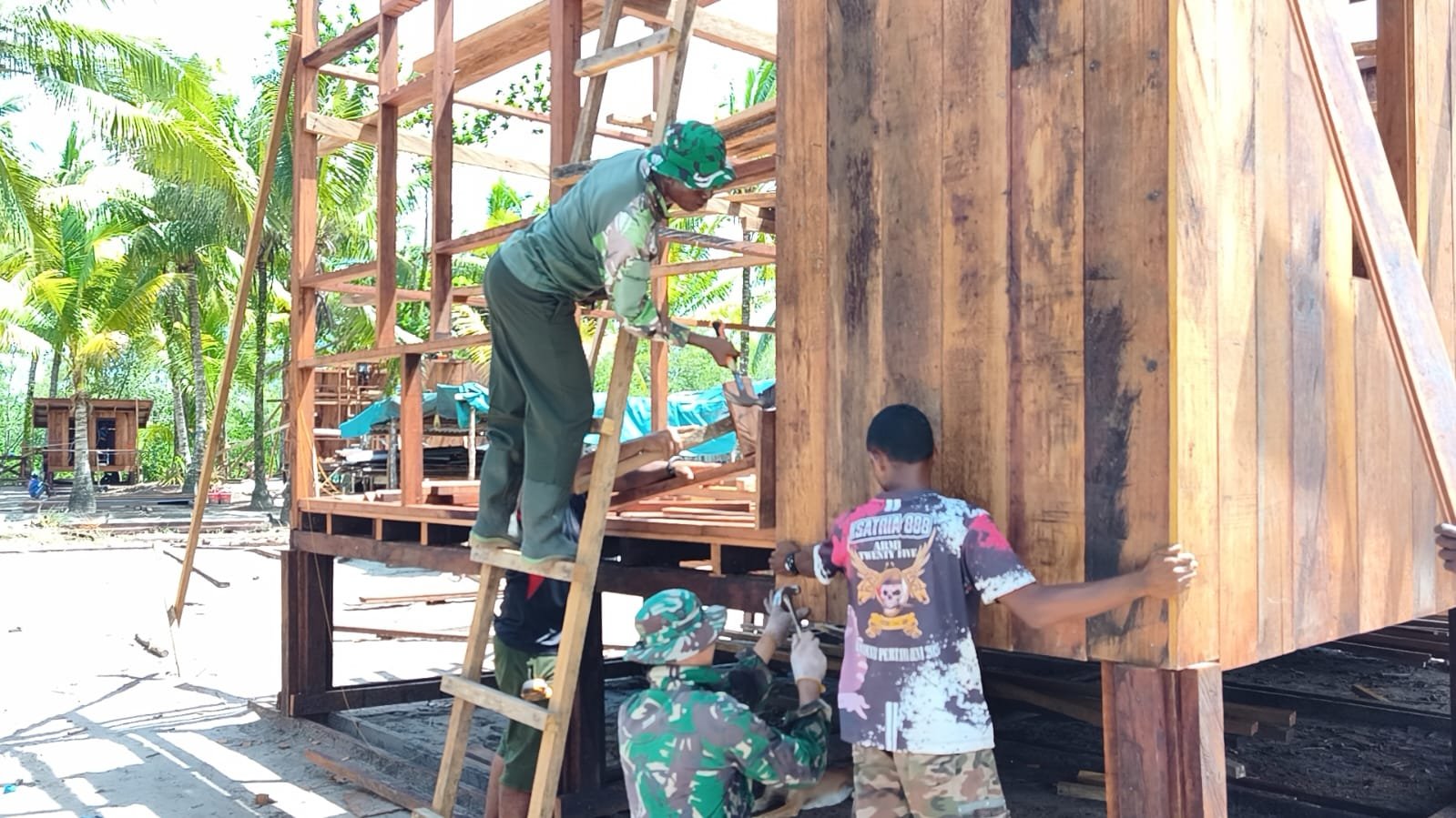 Satgas TMMD dan Warga Kebut Pemasangan Dinding Rumah Niko Makare 
