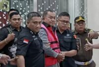 Foto: Wakil Kepala Badan Gizi Nasional (BGN) Lodewyk Pusung, dikawal petugas Kejaksaan Agung usai diperiksa di gedung bundar Kejaksaan Agung, Jakarta. 