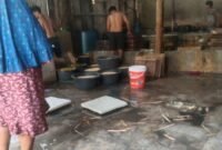 Foto: Pekerja yang sedang mengolah tahu tanpa menggunakan pakaian dan terlihat beberapa nampan tahu yang tergeletak di lantai yang basah dan kotor. (Ag/Suararealitas). 